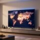 Modern Vizio smart TV in a stylish living room showing global manufacturing locations including China, Mexico, Taiwan, and the USA